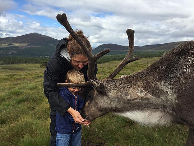 Elizabeth Newcamp and one of her sons feeding reindeer in Scotland