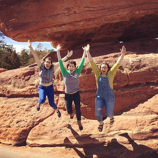 Choir students jumping from red rock formation in Colorado