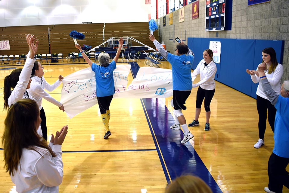 The Sisters of the Holy Cross team comes out onto the court lead by Sister Mary Ann Pajakowski, CSC '69
