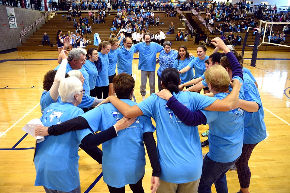 The Sisters of the Holy Cross team gather in a circle on the court prior to the match