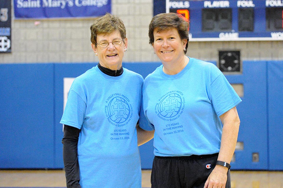 Sister Suzanne Brenna, CSC and Mary Burke '85 pose together after the match wearing thier team jerseys.