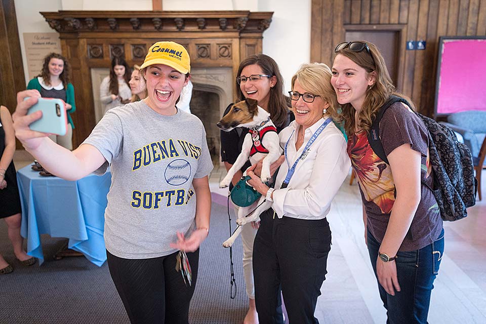 Students take a selfie with President and her dog during a 'Tea with the President' event