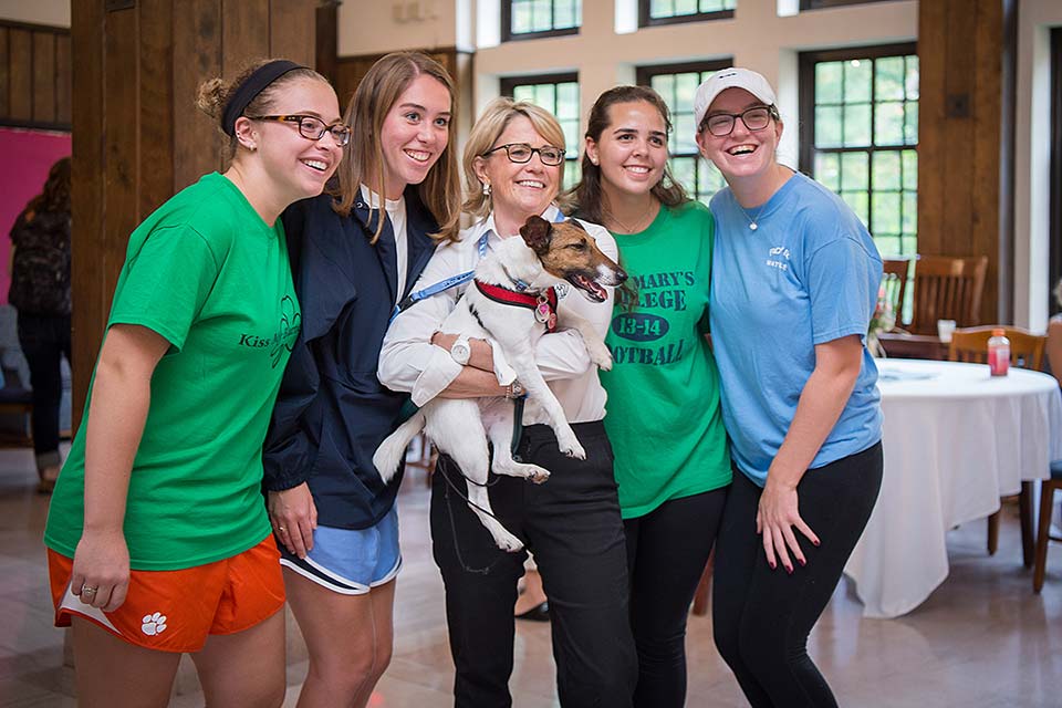Students have their photo taken with President Cervelli and her dog at the 'Tea with the President' event