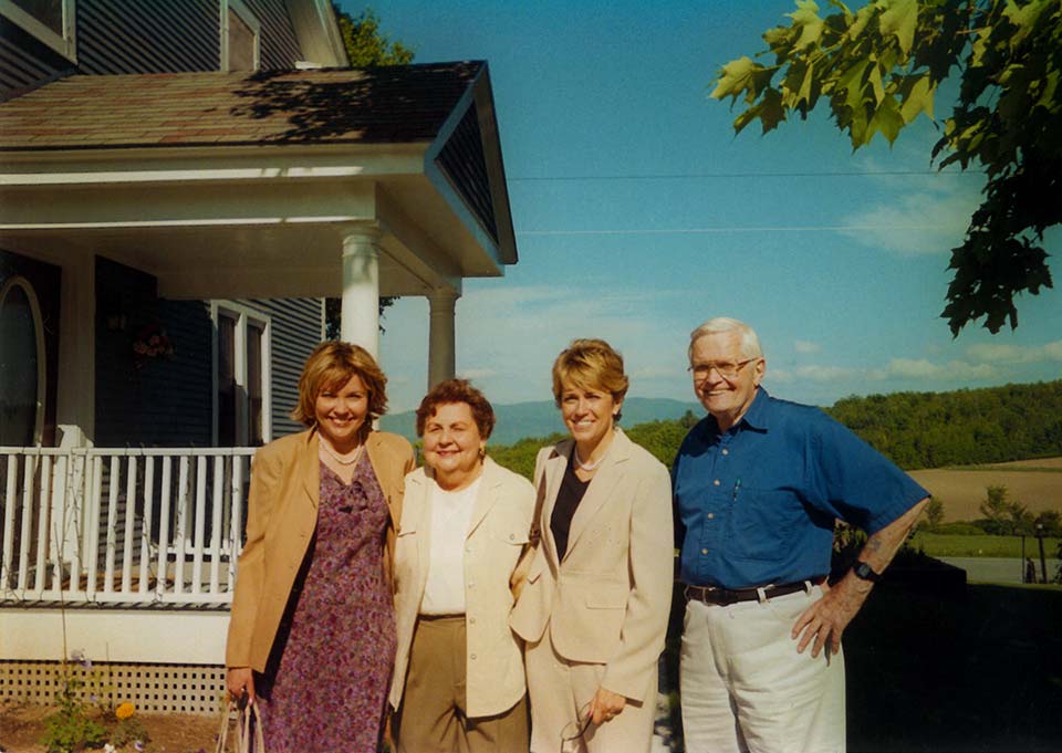 Jan, her sister, and her parents in front of their home.