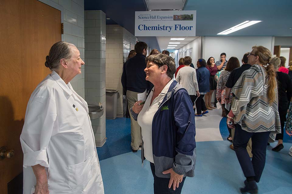 Professor Dorothy Fiegl, speaking with a dedication attendee on the renovated Chemistry floor