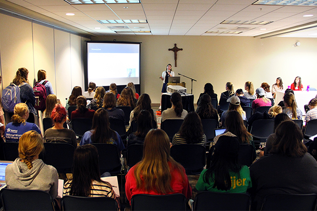 Student presents research to packed room