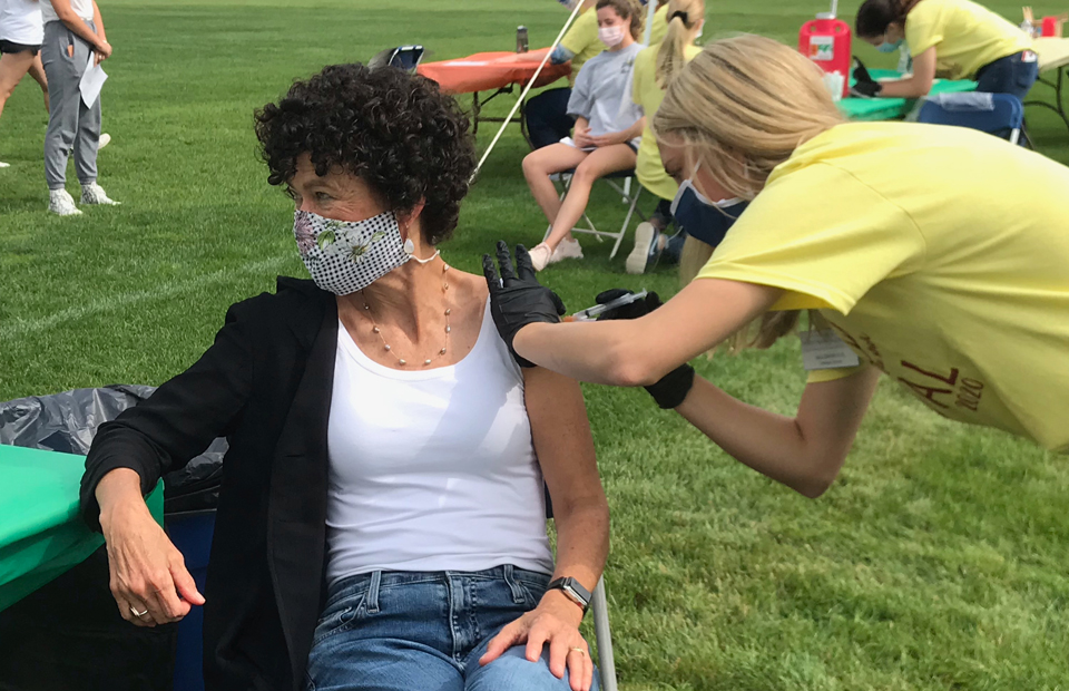 Katie Conboy receives the first flu shot at campus event