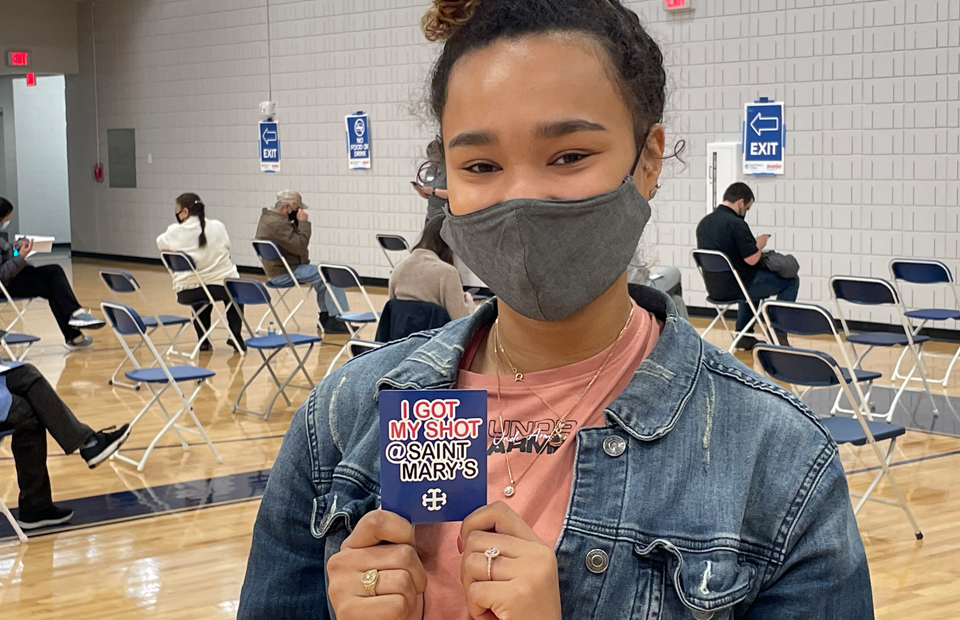 Student holding sticker after getting vaccine