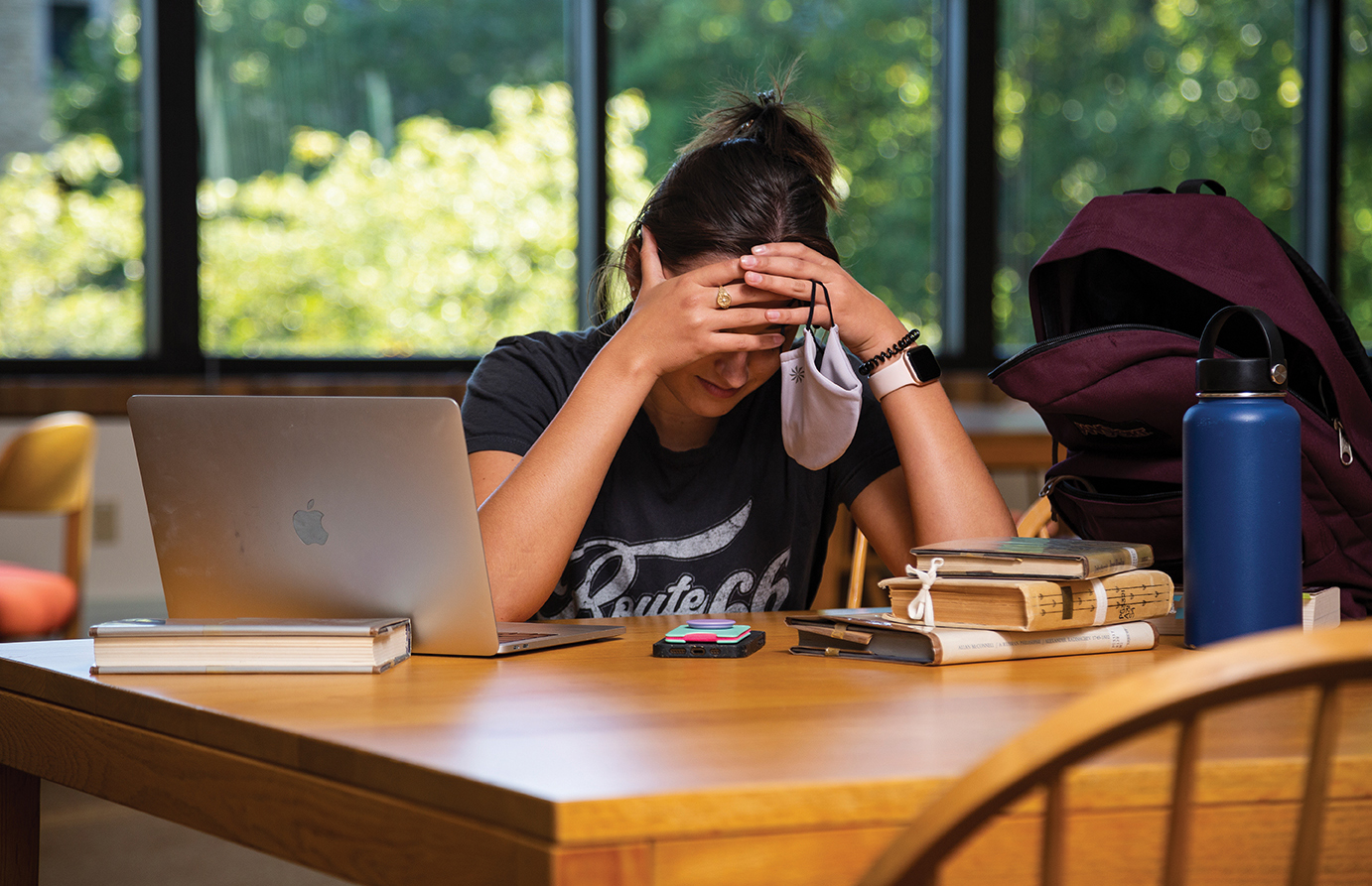 Girl holding her head at study desk