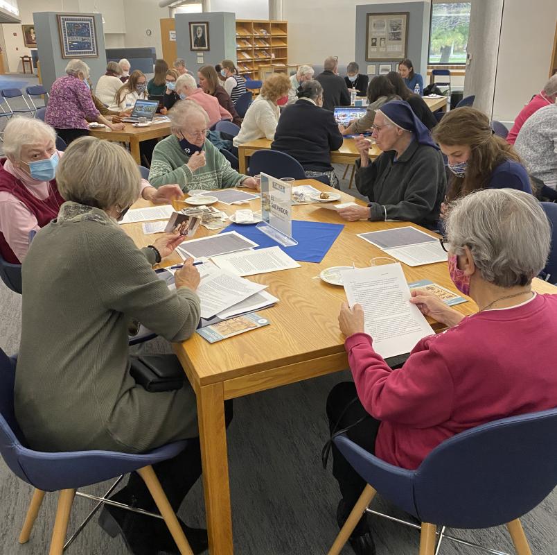 Sister of the Holy Cross viewing artifacts during the table discussions