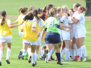 The soccer team rushes onto the field to celebrate Jordan Diffenderfer's (third from right) game-winning goal in overtime.