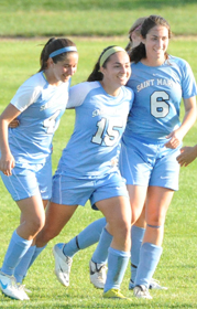 Kelly Wilson, Erin Mishu, and Jordan Diffenderfer celebrate Mishu's goal against Adrian.