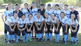 The softball team poses for a photo after defeating Wartburg.
