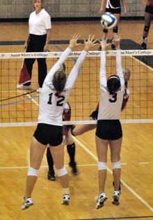 Allison Zandarski (12) and Taylor Etzell (3) go up for a block on Wednesday evening.