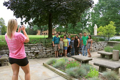 A staff member snaps a photo of a family dropping off a student at McCandless Hall.