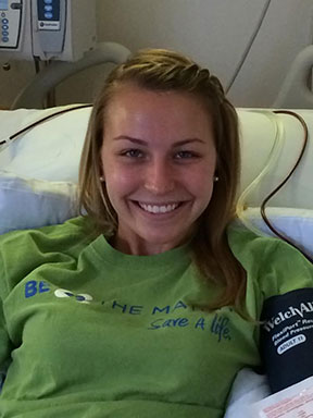 Allison Lukomski '16 smiles from a hospital bed while having her blood drawn for stem cells that may help a woman with cancer beat it. Allison registered in a bone marrow database at a drive on campus last year.