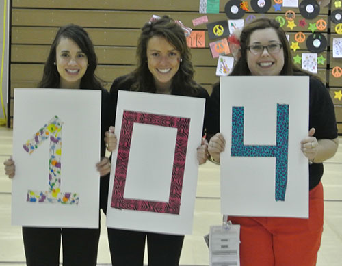 Dance Marathon Vice Presidents Alyssa Vinluan '13 and Kate Kellogg '13 and President Amy Tiberi '13 hold up "104" as in "$104,374.83 this year. 