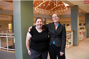 Gina Deom '13 and Kristin Kuter, professor of mathematics share a laugh inside the Student Center.