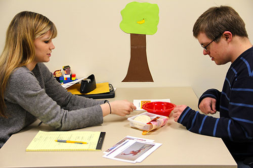 In the newly dedicated Judd Leighton Speech and Language Clinic in Madeleva Hall, Kristine McInerney '14 works with Daniel Ratkiewicz, 15, on his speech and language skills. Here she has him describe the steps of making a pizza.