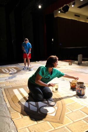 A faculy member and student work on elements of the brand new set. 