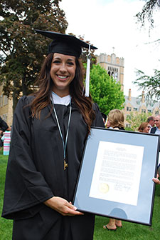 Samantha Grady '15, donning the Lumen Christi medal given to her at Commencement, holds the citation read at the graduation ceremony.