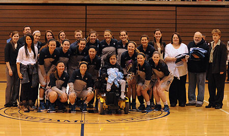 The Saint Mary's basketball team poses with honorary team member Bryanna Sikora, in the center.