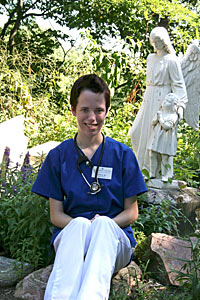 Nursing student Tina Weigle '12 sits by a statue of an angel and child near Holy Cross Hall. Tina hopes to work as a pediatric nurse after graduation.