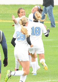 Liza Felix (top left) celebrates with Kelly Wilson and Maggie McLaughlin after scoring late against Trine.