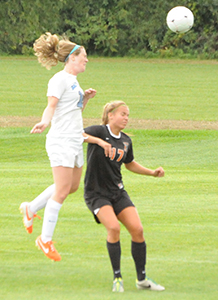 Mary Kate Hussey heads the ball past a defender on its way in for the Belles' goal.