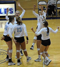 The Belles celebrate a point in the second set against Kalamazoo.