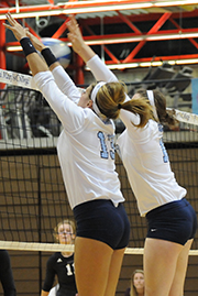 athletes blocking over the volleyball net