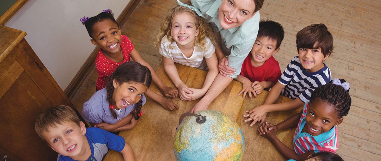 Teacher with children around globe