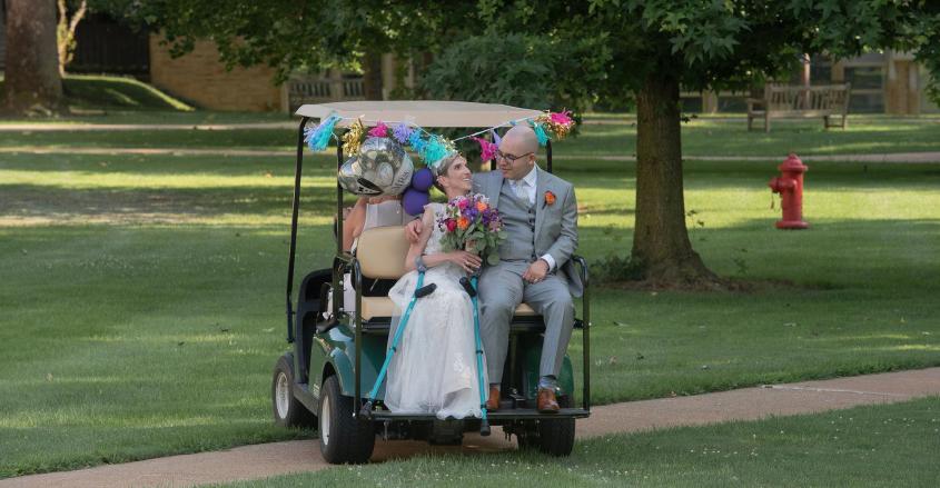 Bride and groom on a golf cart