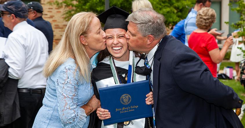 Mom and Dad giving their Graduate a kiss